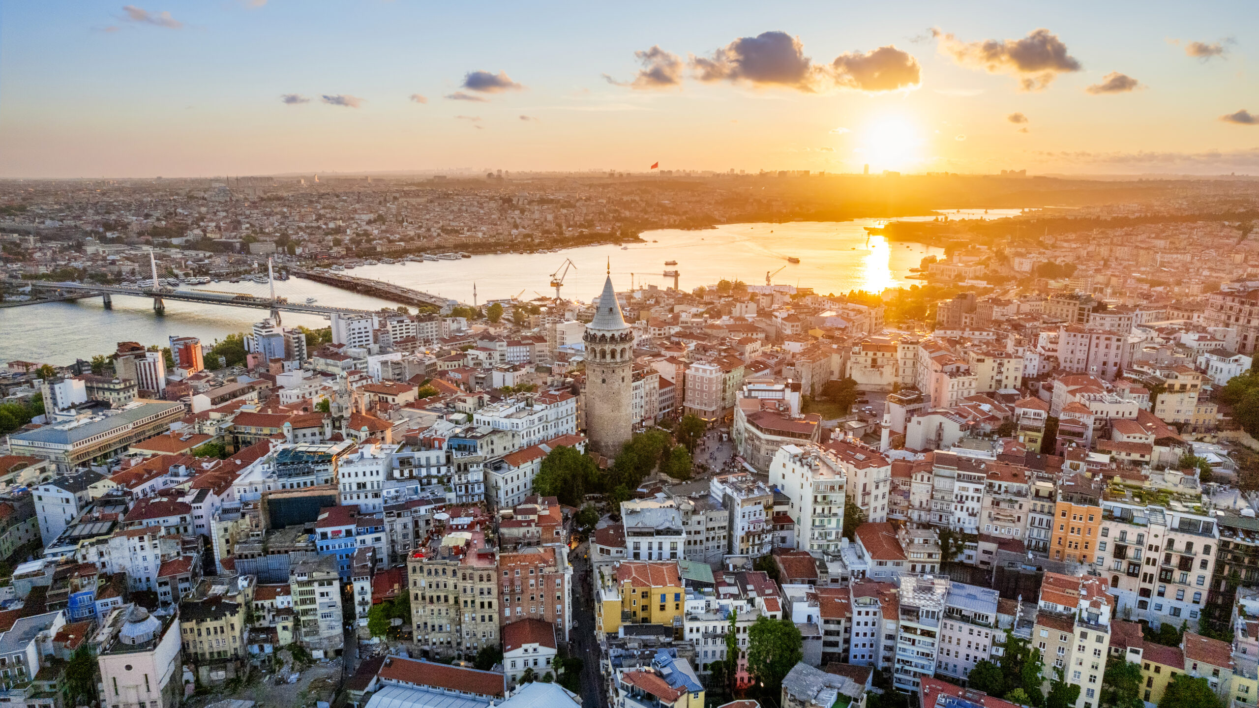 Aerial drone view of Istanbul at sunset, Turkey. Multiple residential buildings around the Galata tower, Golden Horn waterway on the background